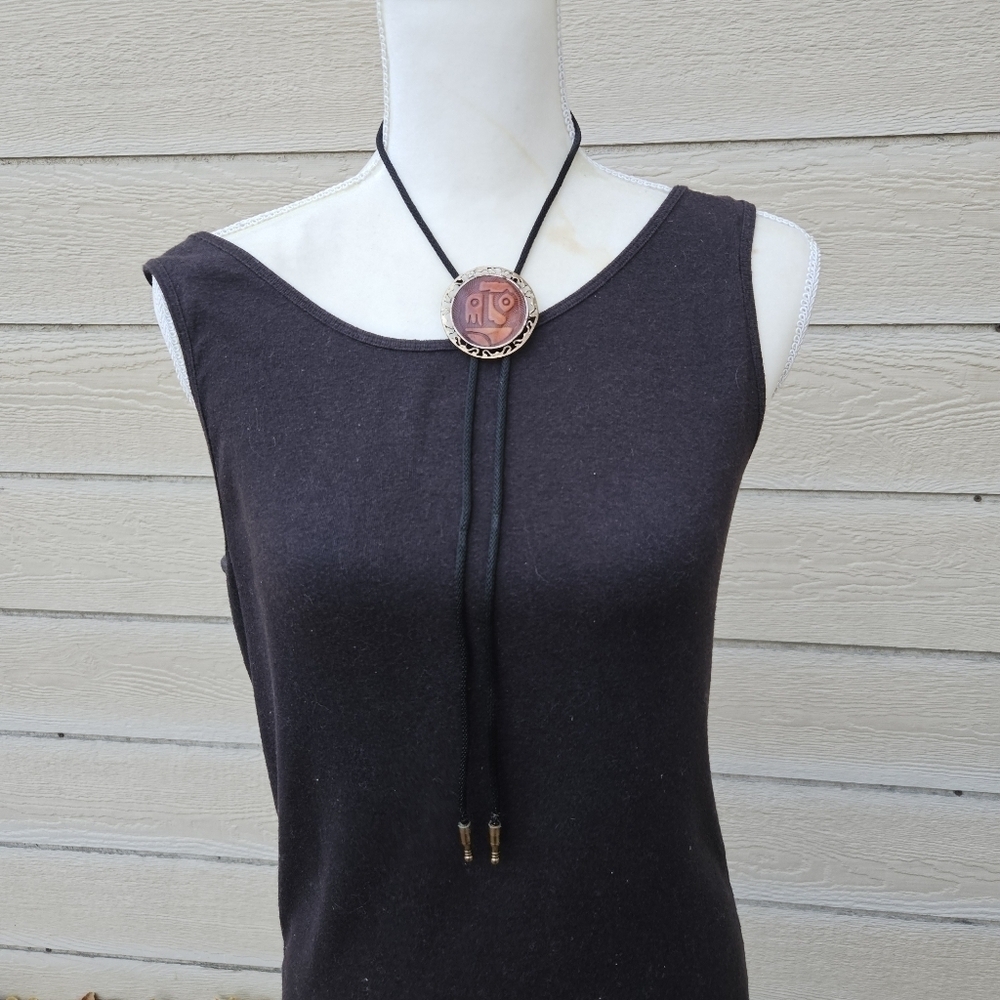gold tone and brown leather abstract face bolo tie on black cord
